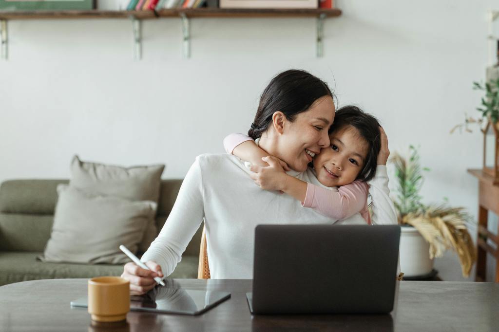 work from home mom smiling at laptop — the real benefits of remote work for moms